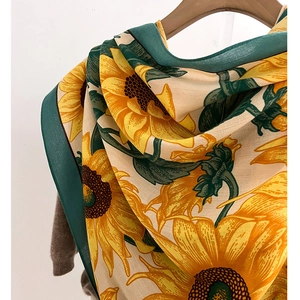 Detail of vibrant sunflower print on high-quality twill scarf with dark green edges
