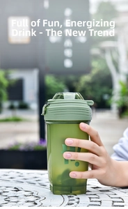 Close-up of hand holding a green translucent shaker bottle with leaf-green frosted lid