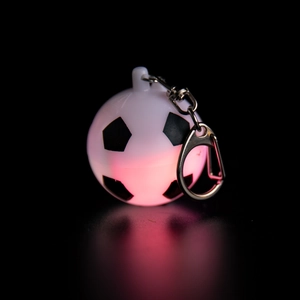 Macro view of glowing football keychain with LED red light effect and metal chain