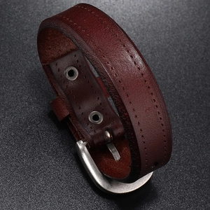 Detail of brown leather bracelet for men featuring metal buckle and decorative stitching