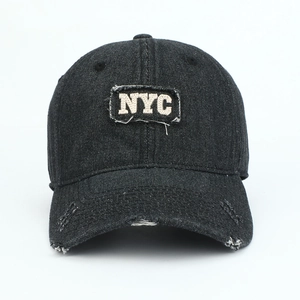 Detailed view of black washed denim NYC baseball cap with vintage distressed embroidery