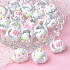 Close-up of colorful hand-painted acrylic beads in glass bowl for DIY jewelry making