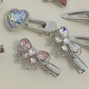 Detail of pink rhinestone heart and bow hair clips with silver alloy finish