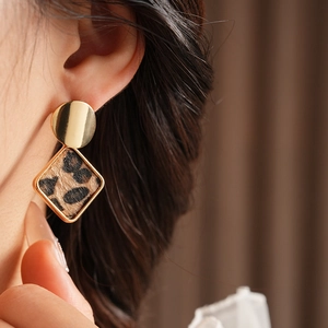 Gros plan sur les boucles d'oreilles carrées imprimé léopard avec bordure en métal doré
