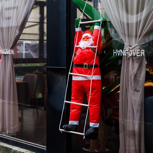 Babbo Natale appeso su scala bianca per decorazioni esterne di pareti e alberi di Natale