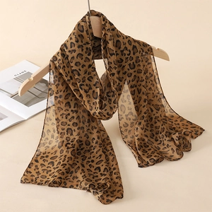 Close-up of lightweight leopard print chiffon scarf draped on a wooden hanger