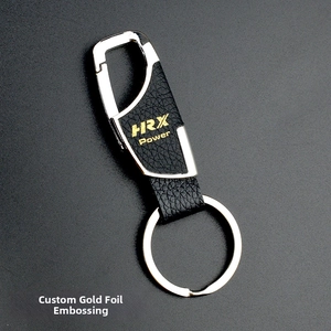 Detail of a business keychain with black lychee leather and gold HRX Power logo