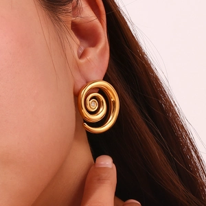 Close-up of 18K gold plated spiral earrings featuring a sparkling zircon stone inlay