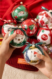 Close-up of festive coral fleece Christmas socks inside a transparent gift ornament ball