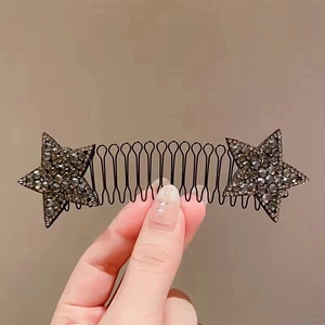 Close-up of black metal hair comb with sparkling rhinestone star-shaped decorations