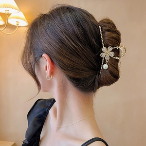 Pince à cheveux fleur dorée ornée de strass brillants et d'un pendentif perle blanche