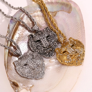 Three tiger head pendants in gold and silver colors on twisted chain with crystals