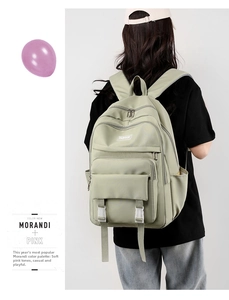 Vista posteriore di uno zaino in nylon impermeabile verde salvia con tasche multiple