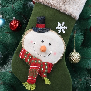 Detail of green plush Christmas stocking with snowman embroidery and faux fur trim