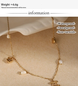 Detail of waterproof stainless steel necklace with pearl, rose, heart and cherry pendants
