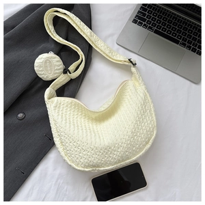 Detail of cream quilted crescent bag with adjustable strap and small round coin purse
