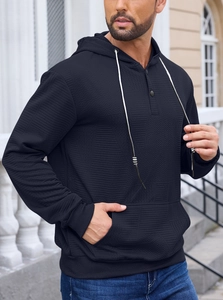Close-up of black herringbone jacquard texture on men's pullover hoodie with drawstring