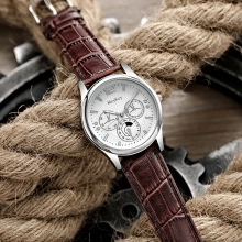 Macro detail of men's quartz watch with brown leather strap on vintage industrial props