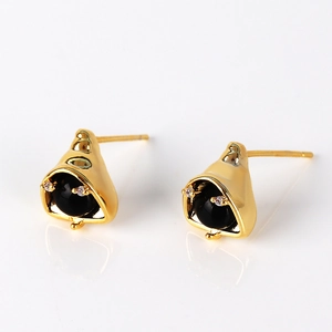 Detail of golden helmet stud earrings featuring a black round gem and pavé accents