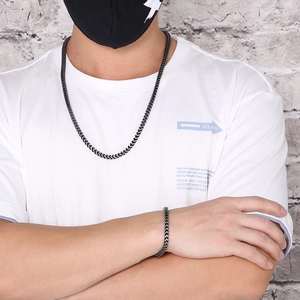 Close-up of black and silver titanium dragon bone chain necklace and bracelet on model