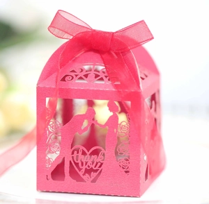 Detailed laser-cut heart pattern on a red wedding favor box with a silk ribbon bow