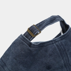 Detail of vintage brass adjustable buckle and washed cotton texture on the baseball cap