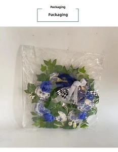 Blue rose wreath with porcelain accents and buffalo plaid bow in packaging