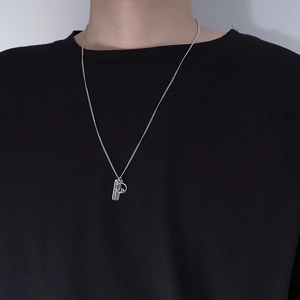Detail of silver dual pendant necklace with engraved rectangular tag and round crest