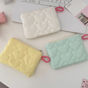Detailed view of quilted heart pattern mini storage bags in pastel colors with zippers