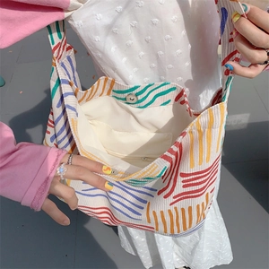 Detail showing the magnetic snap closure and internal zipper pocket of the canvas tote bag