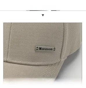 Détail d'une casquette beige Narason avec logo métallique et coutures précises du tissu