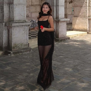 Détail de la robe en maille noire transparente avec paillettes et rubans élégants