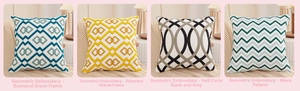 Detail of four geometric embroidered cushions with diamond and wave patterns on soft cotton