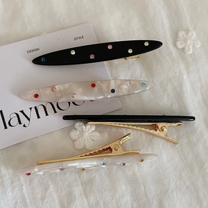 Set of four colorful rhinestone acetate hair clips with marble texture on textile