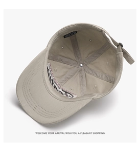 Internal view of beige cotton baseball cap showing stitching, lining and care label