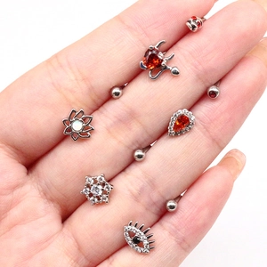 Close-up of 8-piece silver stainless steel body piercing set with heart and eye charms