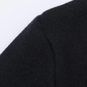 Nahaufnahme von schwarzem Strickkleid-Stoff mit nahtlosem Schulterstich und Textur