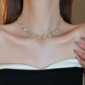 Vue détaillée d'un collier doré avec zircons blancs porté par un mannequin féminin