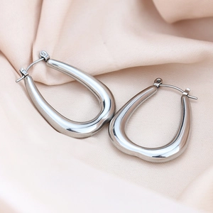 Macro detail of silver U-shaped titanium steel earrings with polished mirror finish