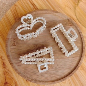 Detailed view of pearl hair claws in heart, rectangle, and triangle geometric shapes
