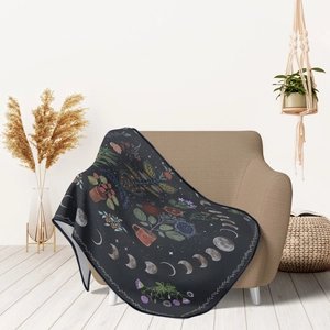 Floral dark gray flannel blanket with moon phases draped over a sofa in a bright home