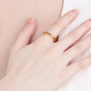 Detailansicht eines goldfarbenen, quadratisch ausgeschnittenen Edelstahlrings am Finger