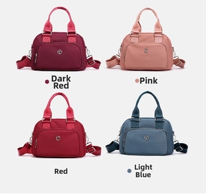 Detailed view of large nylon cross-body bags in dark red, pink, red and light blue colors