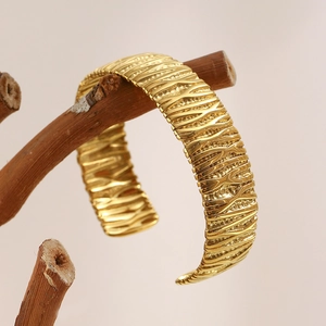 Bracelet manchette en acier inoxydable doré 18K avec texture ondulée sur une branche