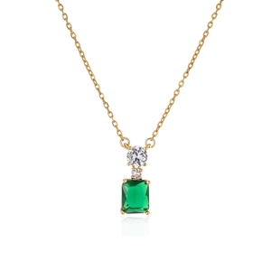 Macro shot of rectangular emerald stone pendant with gold chain and zircon accents