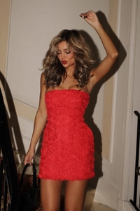 Détail de la robe bustier rouge avec des textures de roses 3D et une coupe moulante
