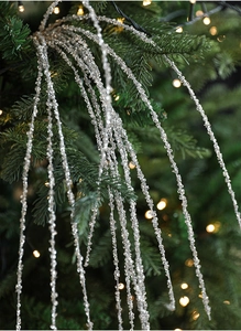 Zilveren kersttakken met pailletten hangend in een boom met warme sfeerverlichting