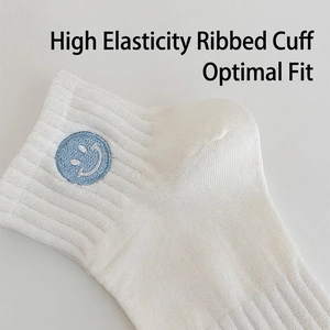 White cotton ribbed ankle socks with light blue smiling face embroidery and elastic cuffs