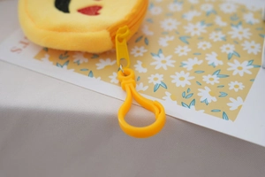 Close-up of yellow plastic hook attachment and plush detail for cartoon shoulder bag