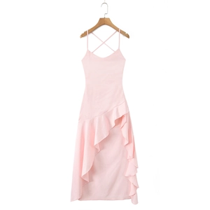 Detail of pink slip dress showing the ruffled hem and side slit design on a white background